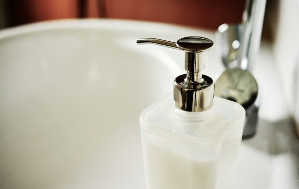 Soap dispenser on a clean sink after cleaning bathroom floor.